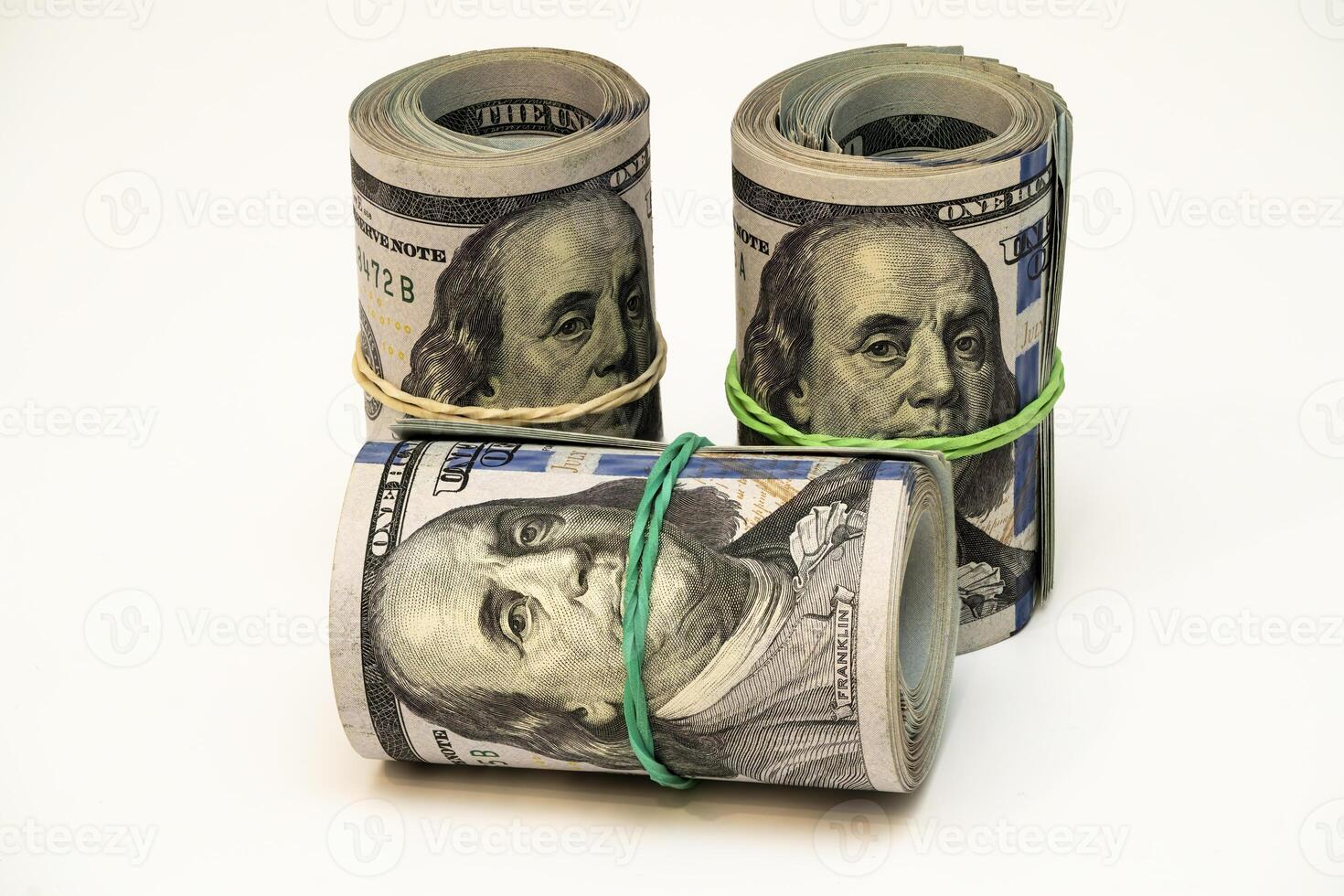 Stacks of dollar bills wrapped with rubber bands on a white surface photo