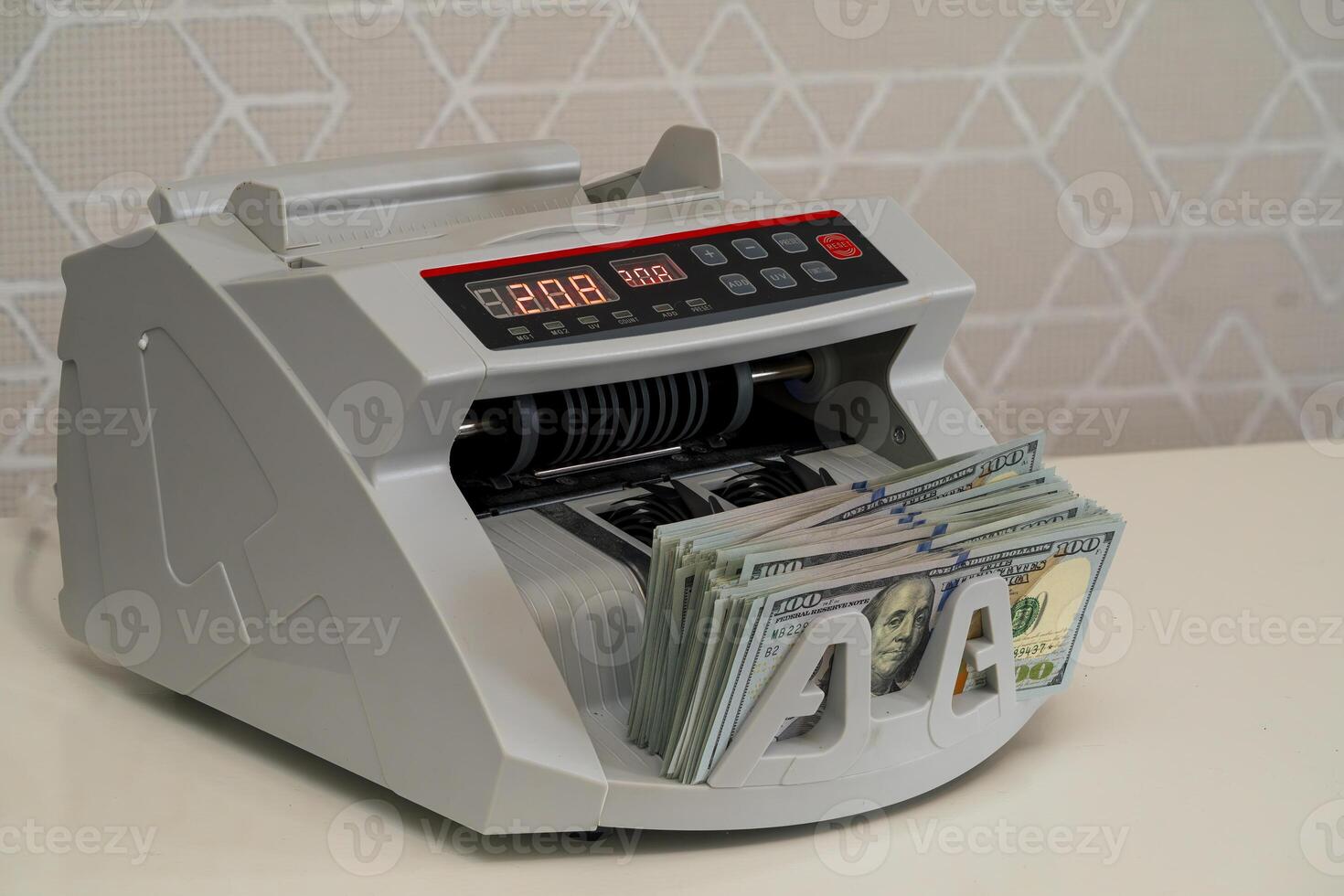 Cash counting machine efficiently processing dollar bills at a bank photo