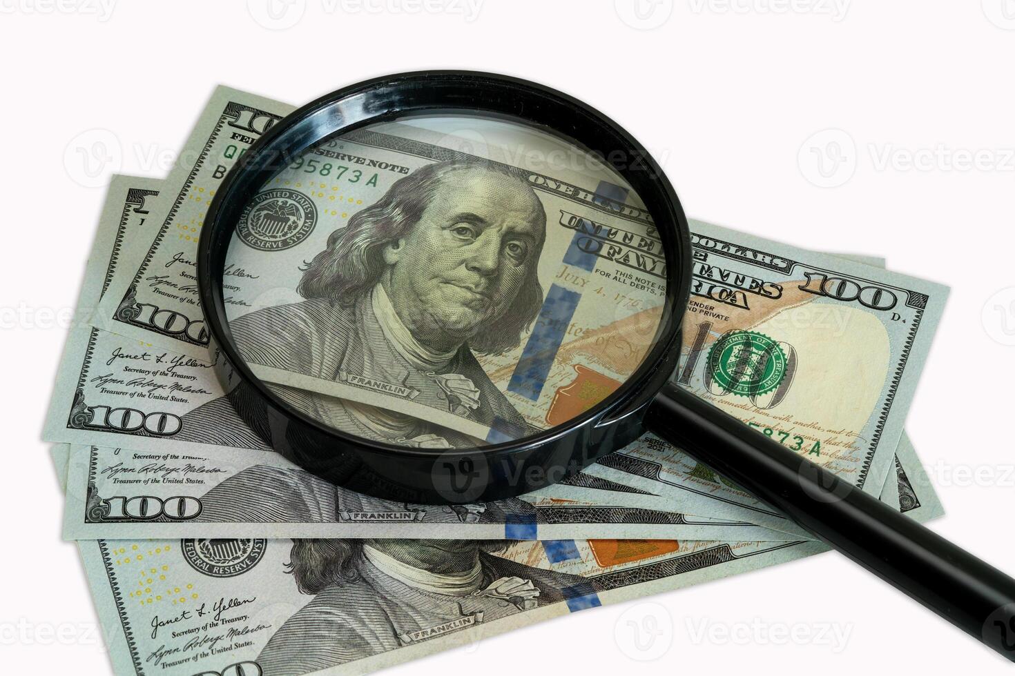 Discovering details of hundred dollar bills with a magnifying glass photo