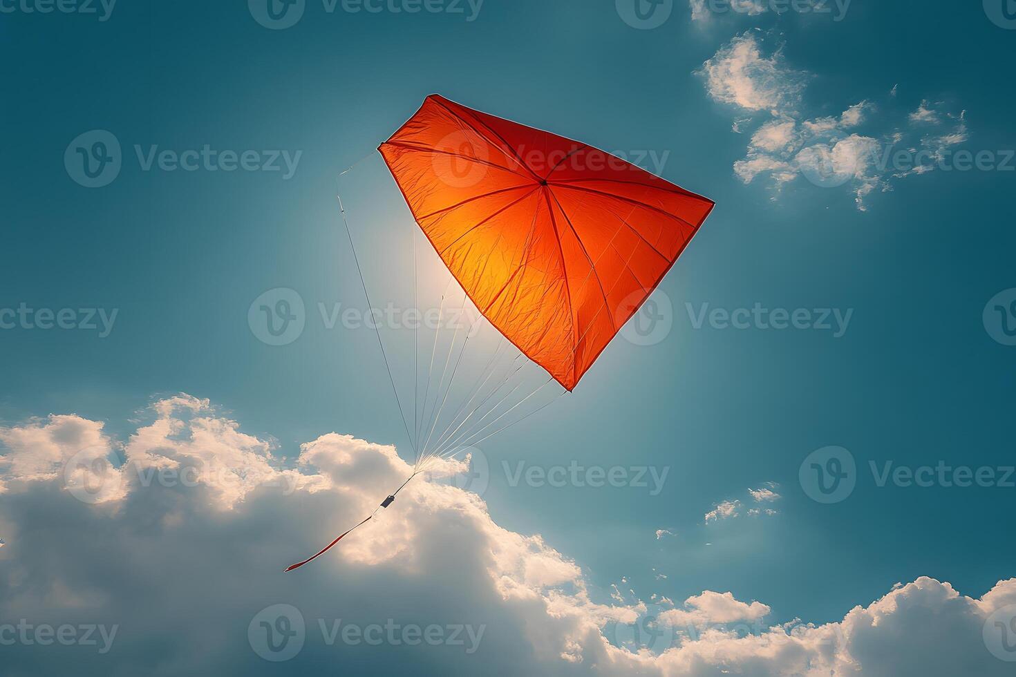 Joyful Summer Adventure with a Bright Red Kite Soaring in the Clear Blue Sky photo