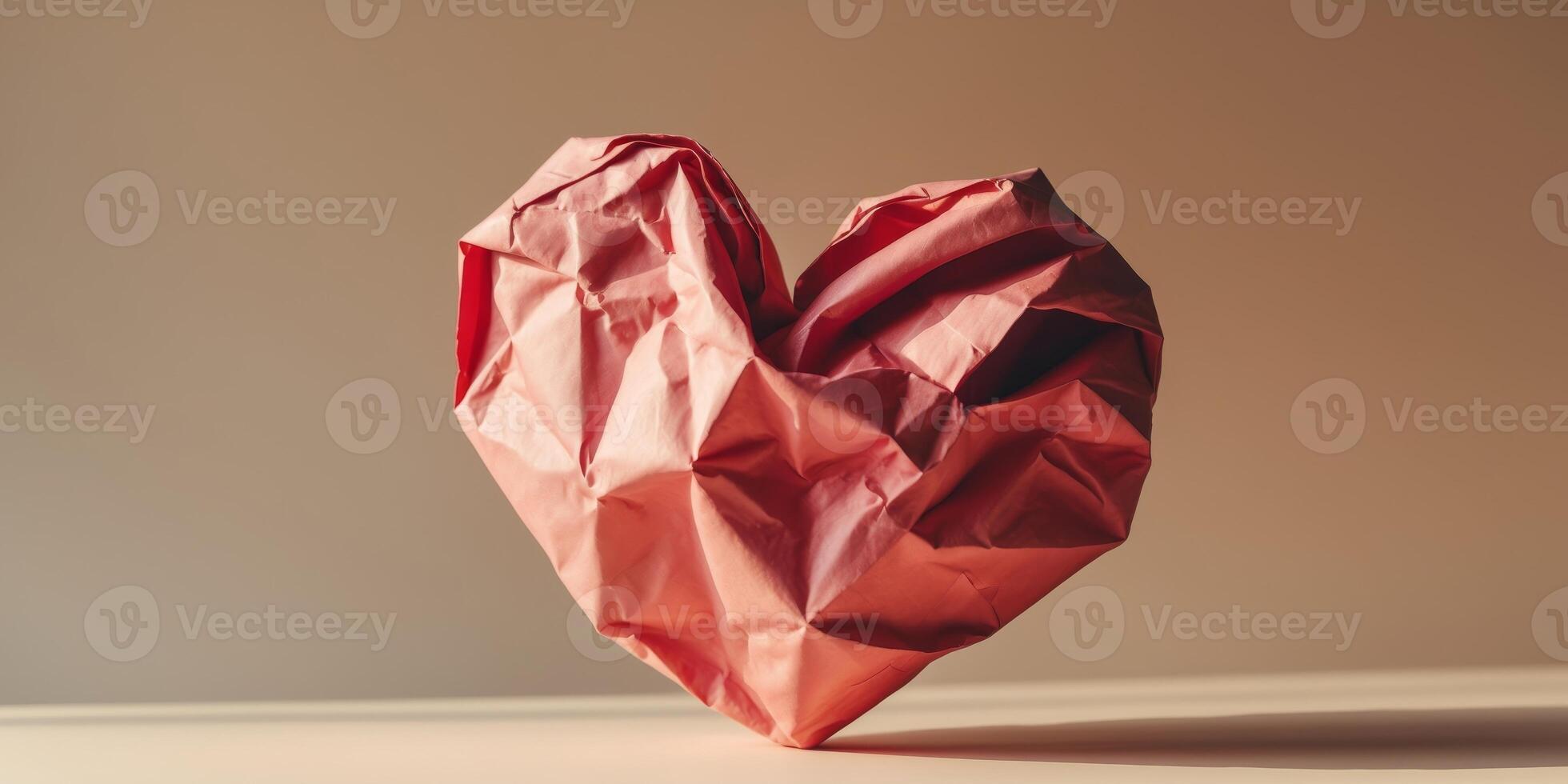 Red crumpled paper heart on beige background. photo