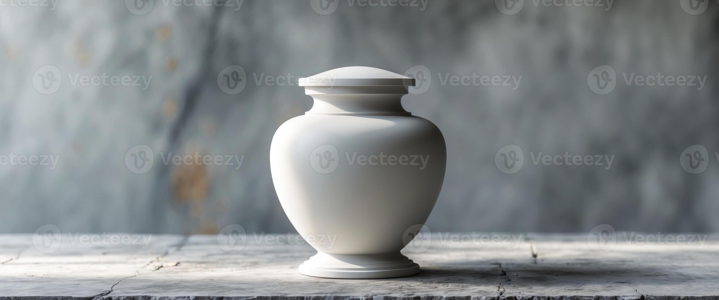 Elegant funeral urn on gray textured background with soft light highlighting its feature photo