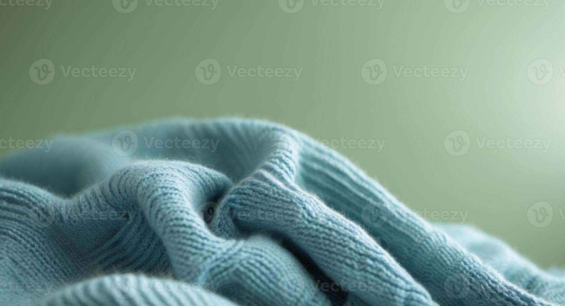 A close up of a blue knitted blanket on a green background. photo