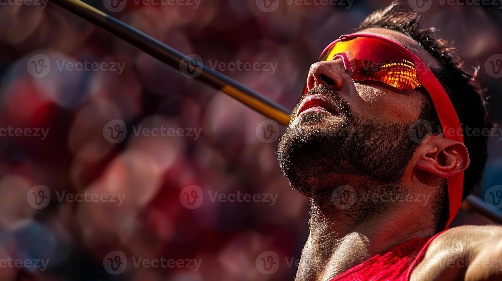 Indian para athlete focuses intently as he throws javelin prosthetic arm. stadium buzzes energy in bright sunlight capturing his determination and skill photo