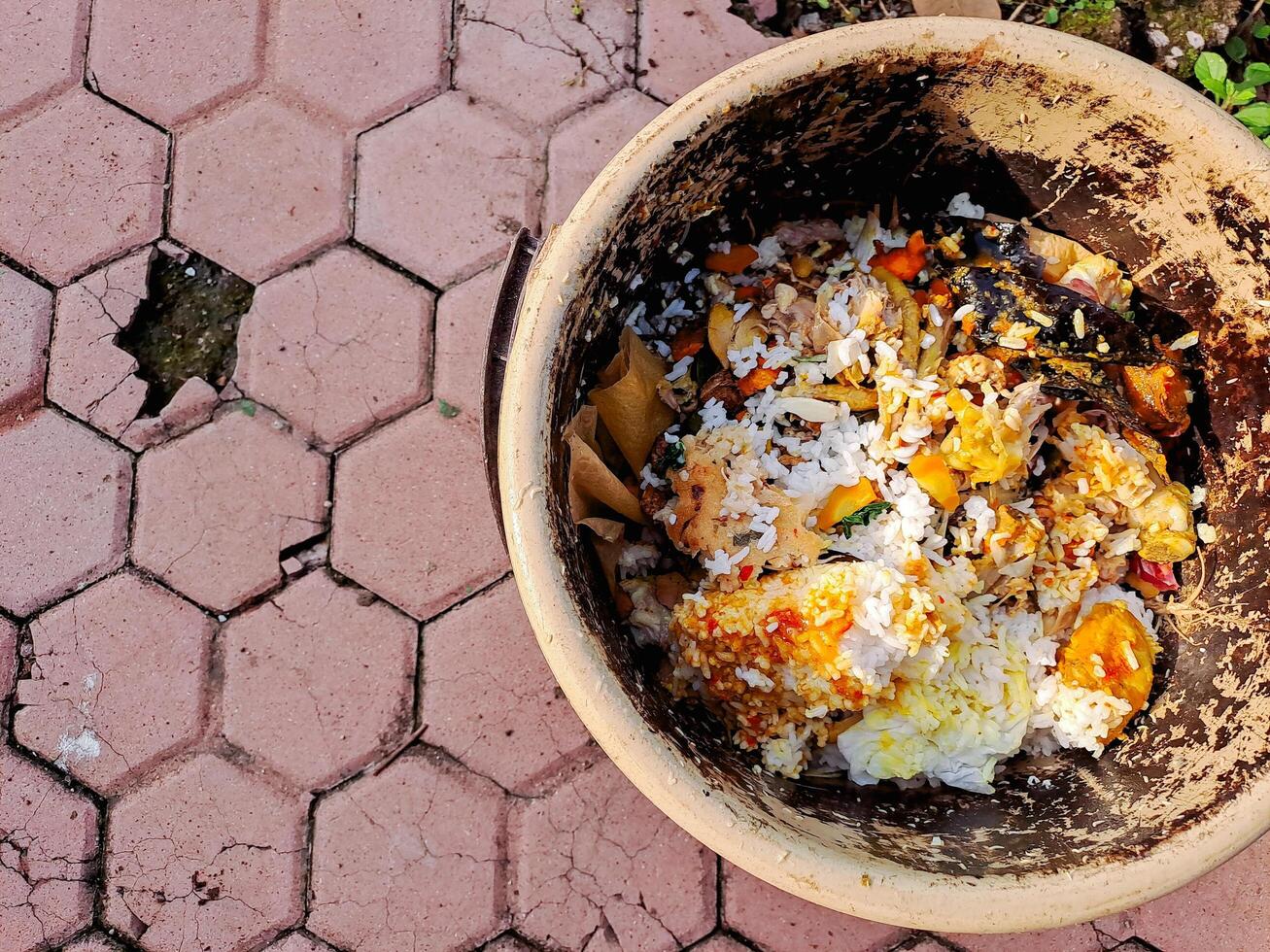 A brown bowl filled with food on a brick patio photo