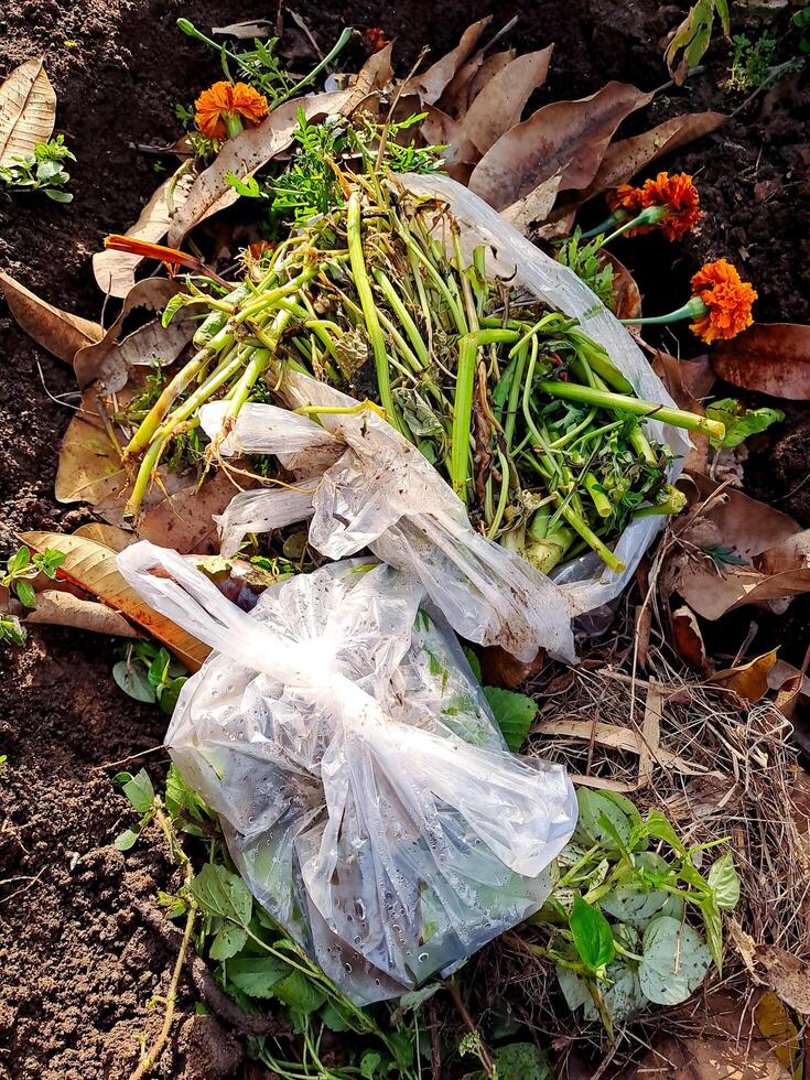 A bag of flowers and weeds sitting on the ground photo