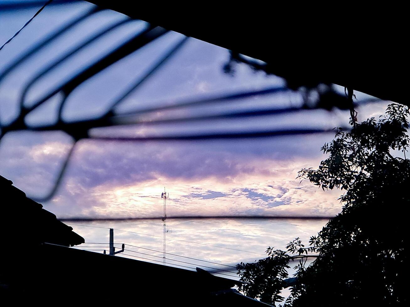 A view of a sky with clouds and a tree photo