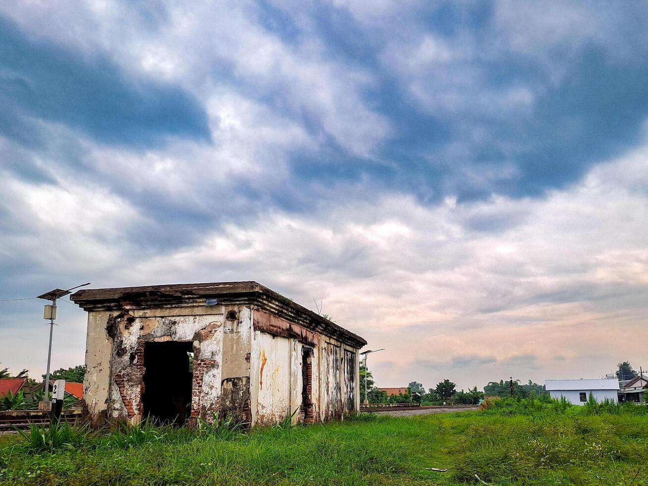 An old building sits in the middle of a field photo