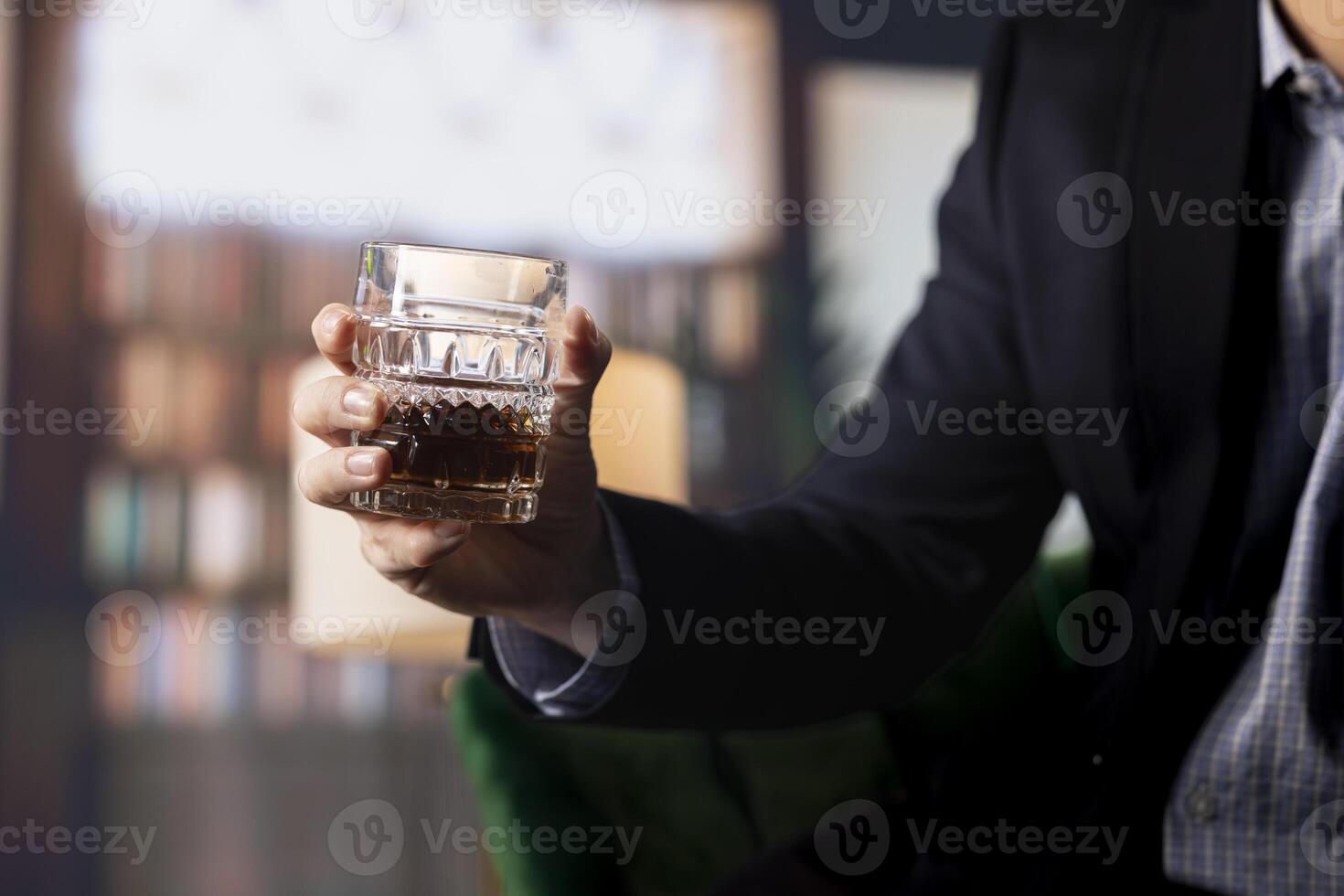 Two partners drinking glass of whiskey in the social club library, discuss career goals and perspectives to double fortune. Upper class elite gentlemen serving scotch and do business. Close up. photo
