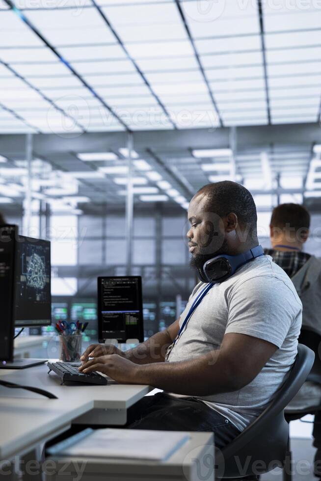 Smiling technician working in high tech workplace providing computing resources for different workloads. Radiant IT specialist tasked with monitoring data center mainframes photo