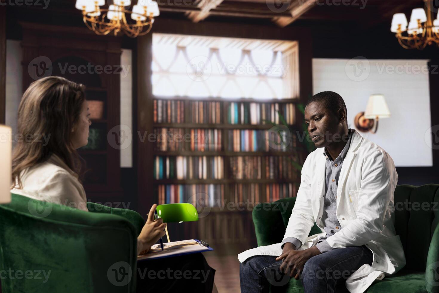 Professional counselor in therapy session with black medic experiencing trauma after losing patients, discussing stress disorder and anxiety. Psychological health and support system. photo
