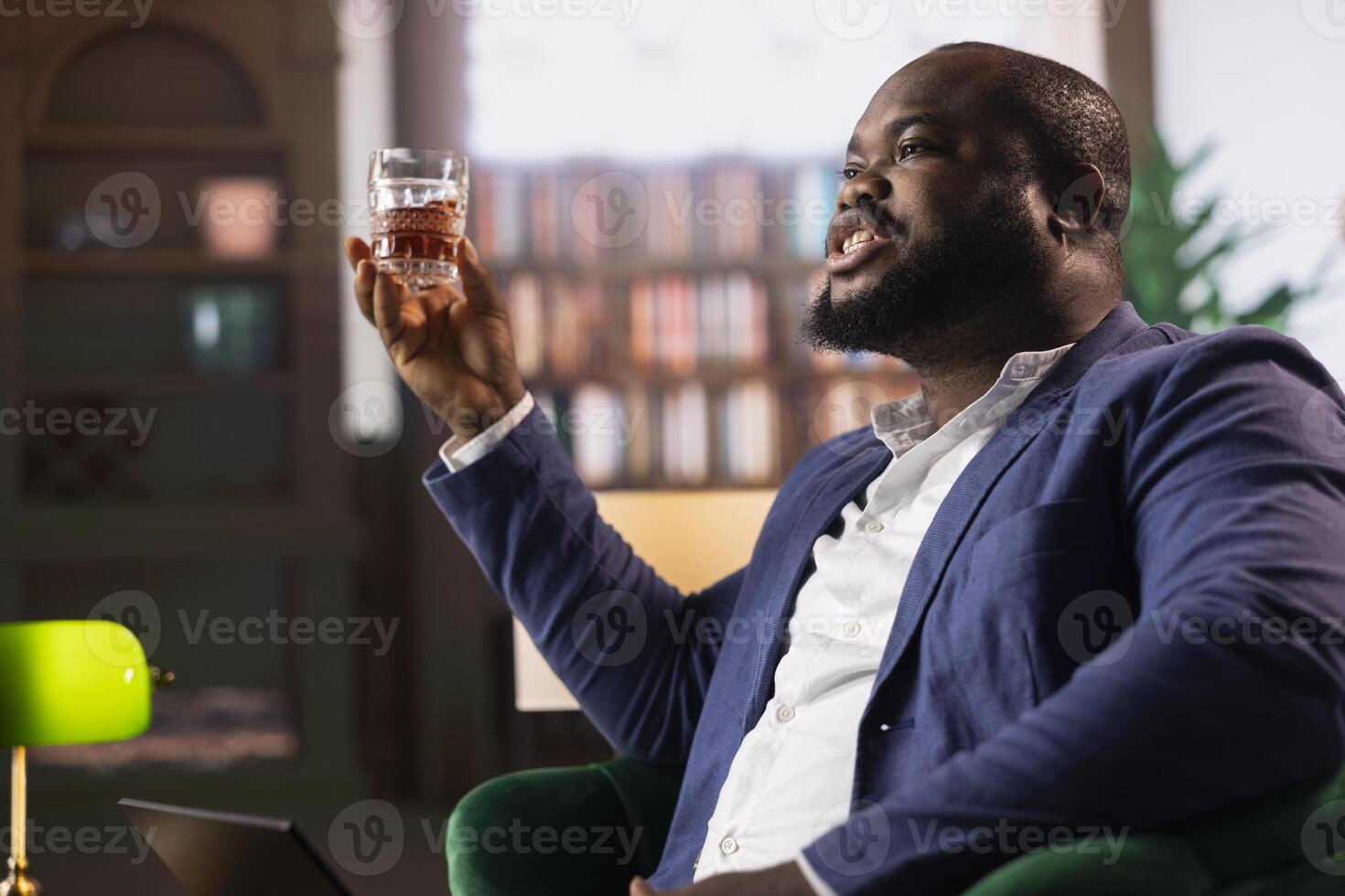 African american professional enjoying a scotch during meeting at a dandy club with a partner, focusing on collaboration and making a fortune. Upper class negotiations between old money heirs. photo