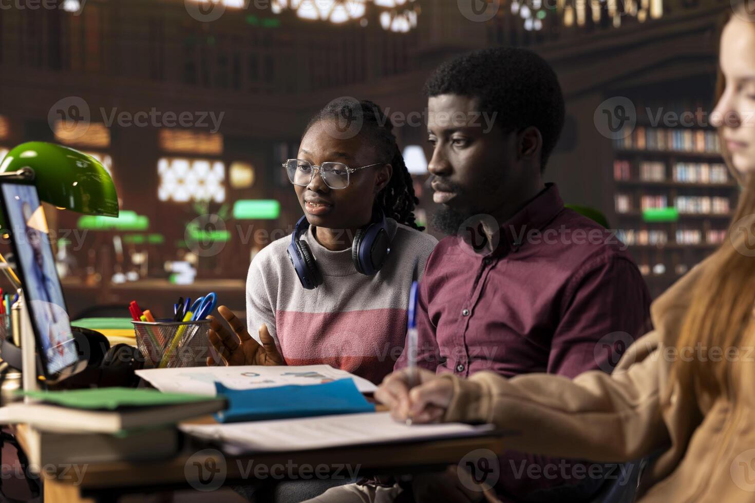University students in a library use online conferencing to attend a telehealth class, discussing microbiology and medical techniques to practice later with a specialist. Medical academy. photo