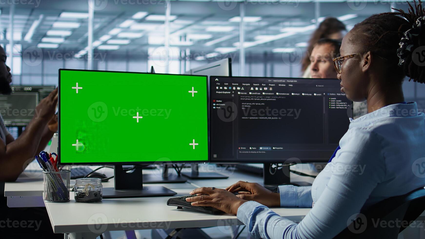 IT technician looking at green screen PC, working in data center, ensuring optimal performance. Employees monitoring energy consumption across server rigs using chroma key monitor, camera B photo