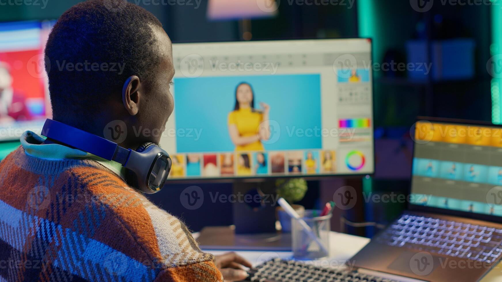 Black man photo editor in a well organized workspace editing images on dual monitors using advanced software tools, displaying creativity and professional dedication. Computer setup. Camera A.