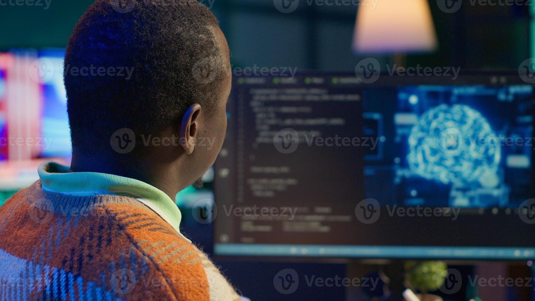 African american man working on computer to write code and programming in artificial intelligence and deep learning. Male IT engineer using pc to ensure cyber security, neural network. Camera A. photo