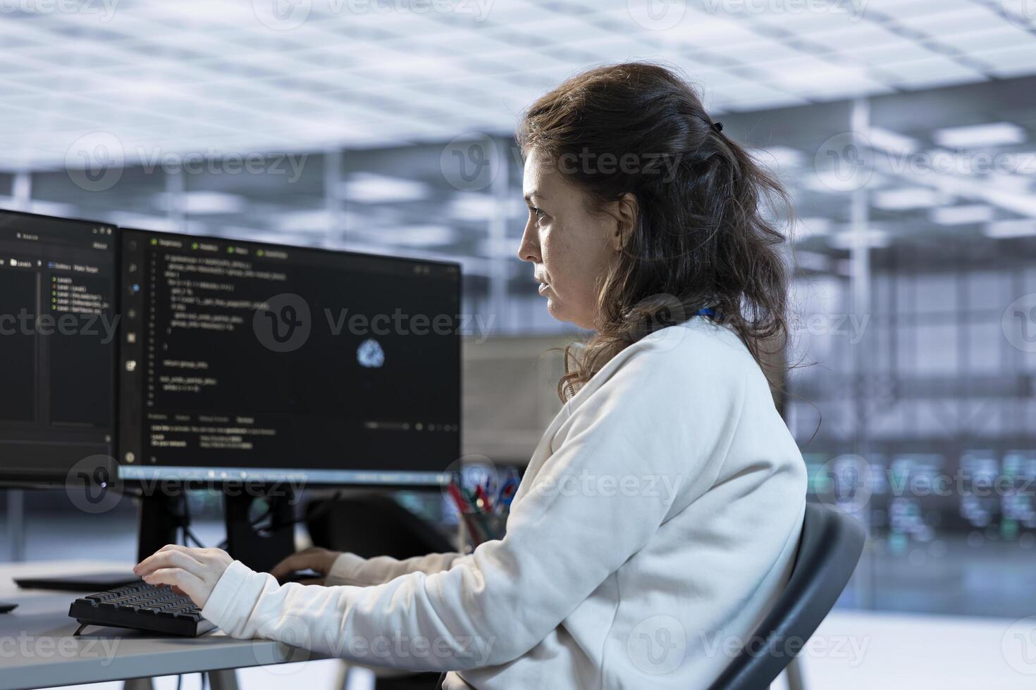 Hardworking technician working in high tech workspace providing computing resources for different workloads. Woman in office tasked with monitoring data center supercomputers photo