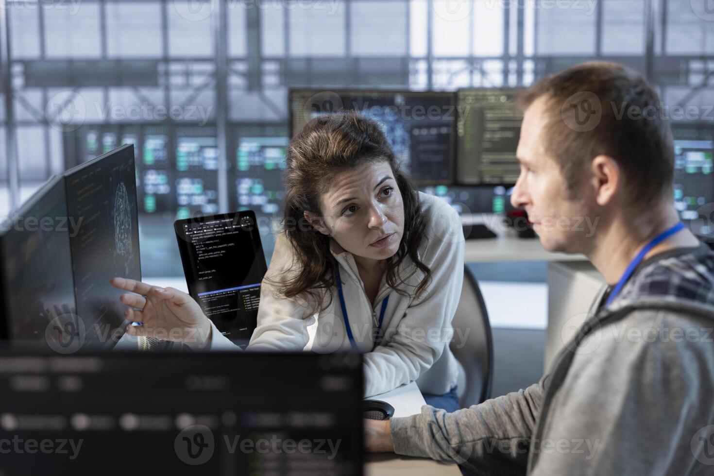 Teamworking colleagues using machine learning to optimize data center operations, improving efficiency of infrastructure. Manager discussing with worker, implementing server virtualization photo