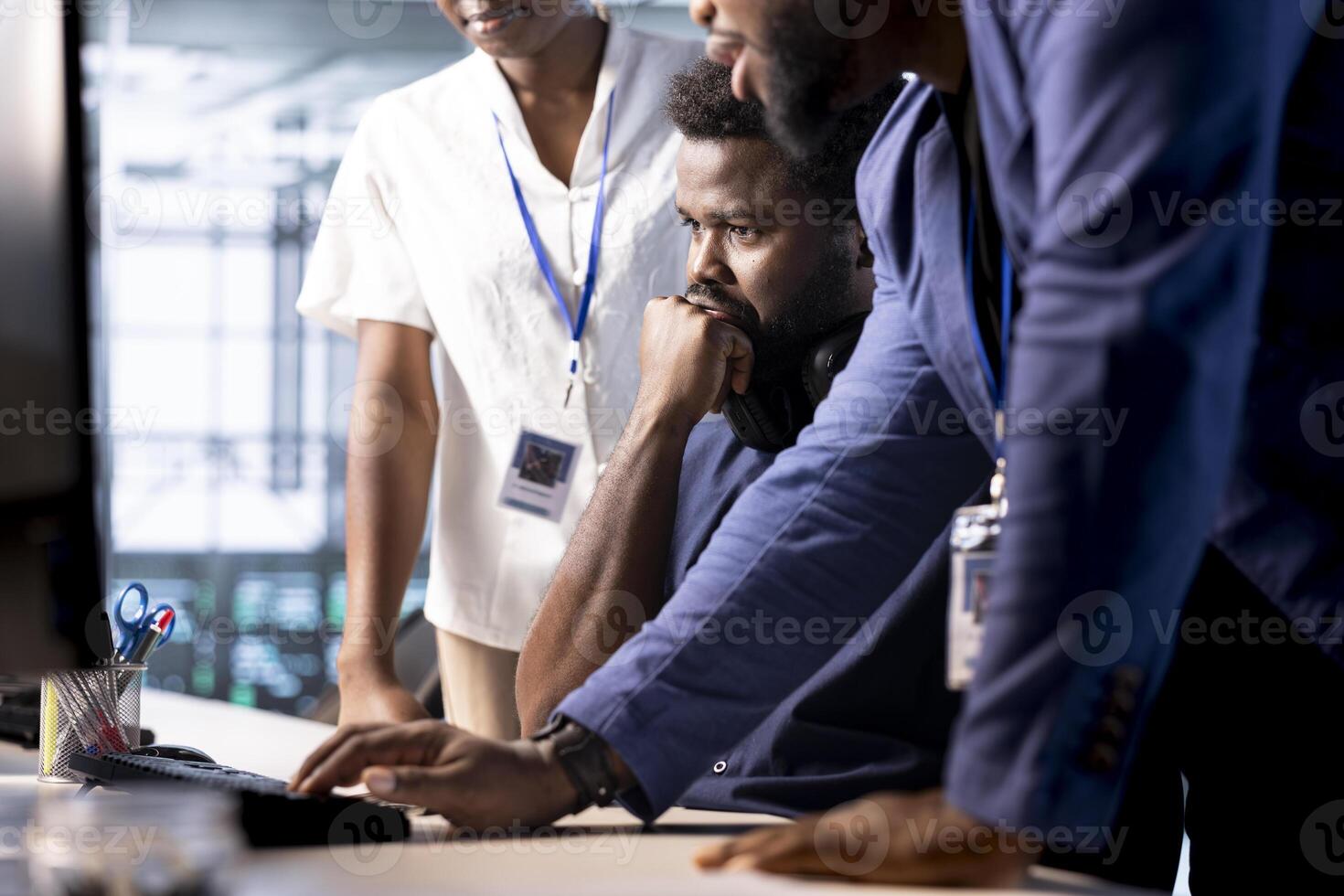 Team of data center program developers creating technical documentation for software applications. System administrators in server room using computer, maintaining databases photo