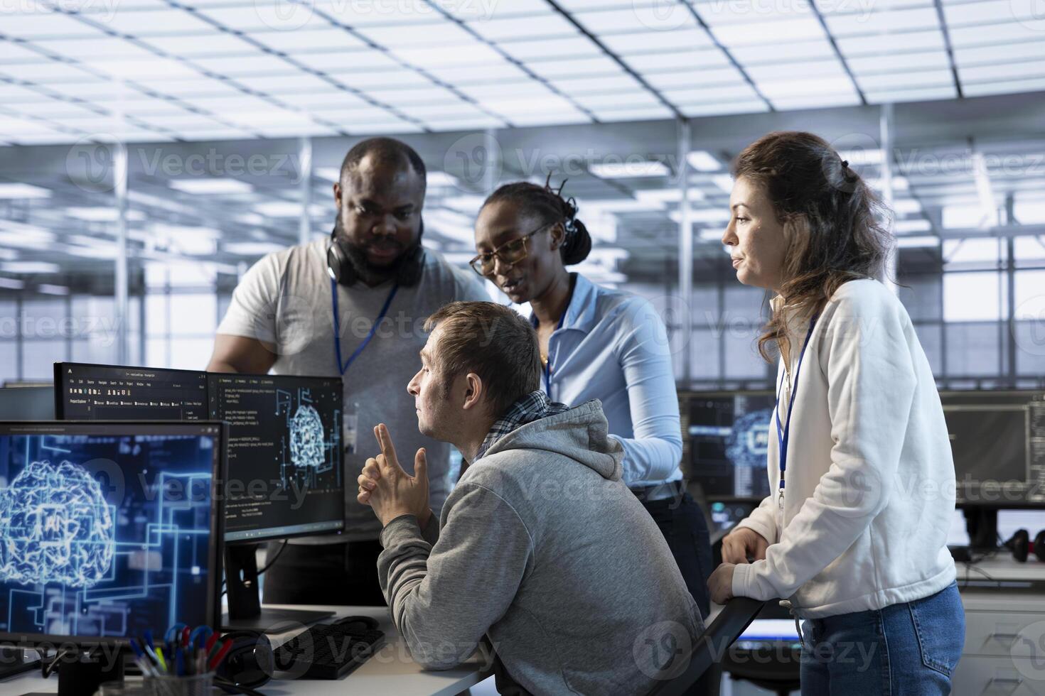 Manager doing team meeting with technicians, delegating tasks in high tech data center office. Supervisor doing brainstorming with IT specialists, telling them how to monitor AI supercomputers photo