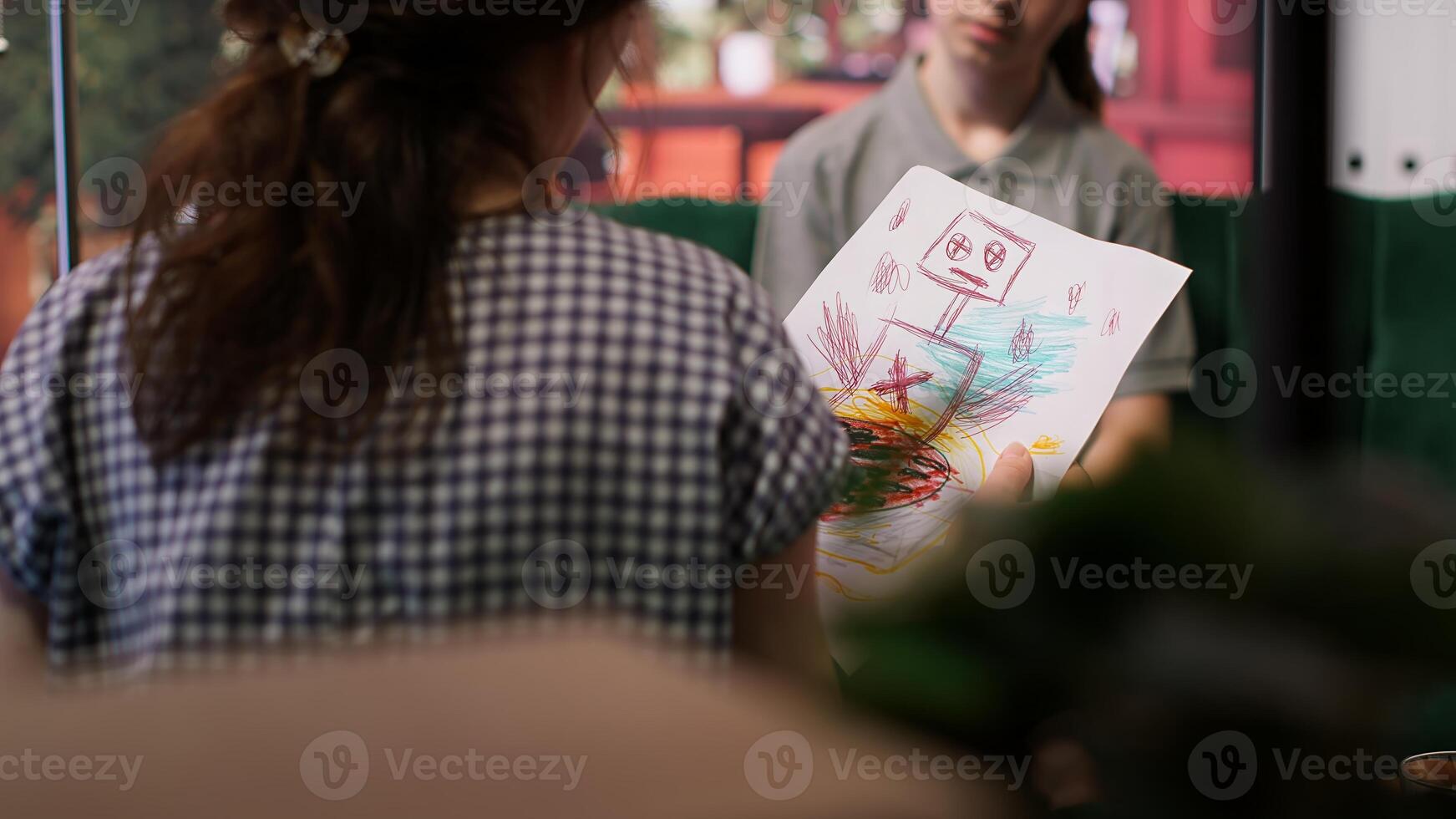 Teenager showing dark gory sketches that reveal anxiety and warning signs, violent thoughts during a therapy session. Psychologist analyzes disturbing art, searching for signs of hostility. Camera A. photo