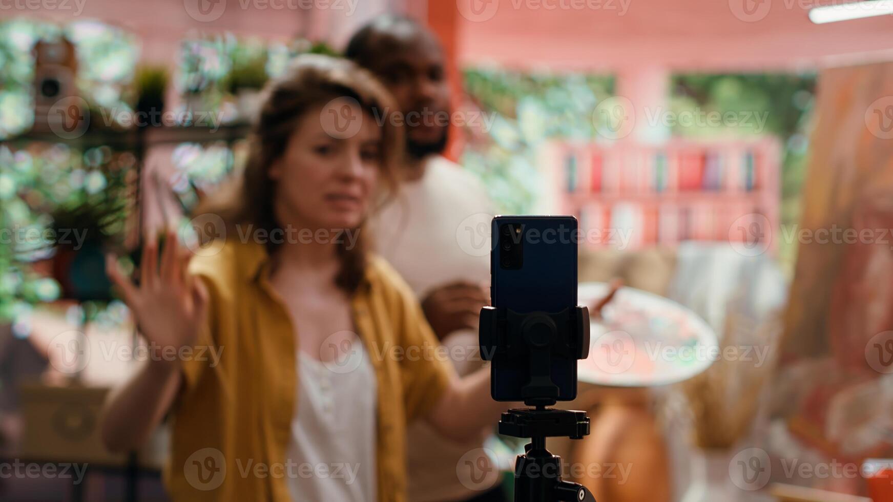 Woman artist hosting online class to present products and technique used on rustic artwork, recording tutorial online. Team of painters doing master class for e learning, art instruction. Camera A. photo