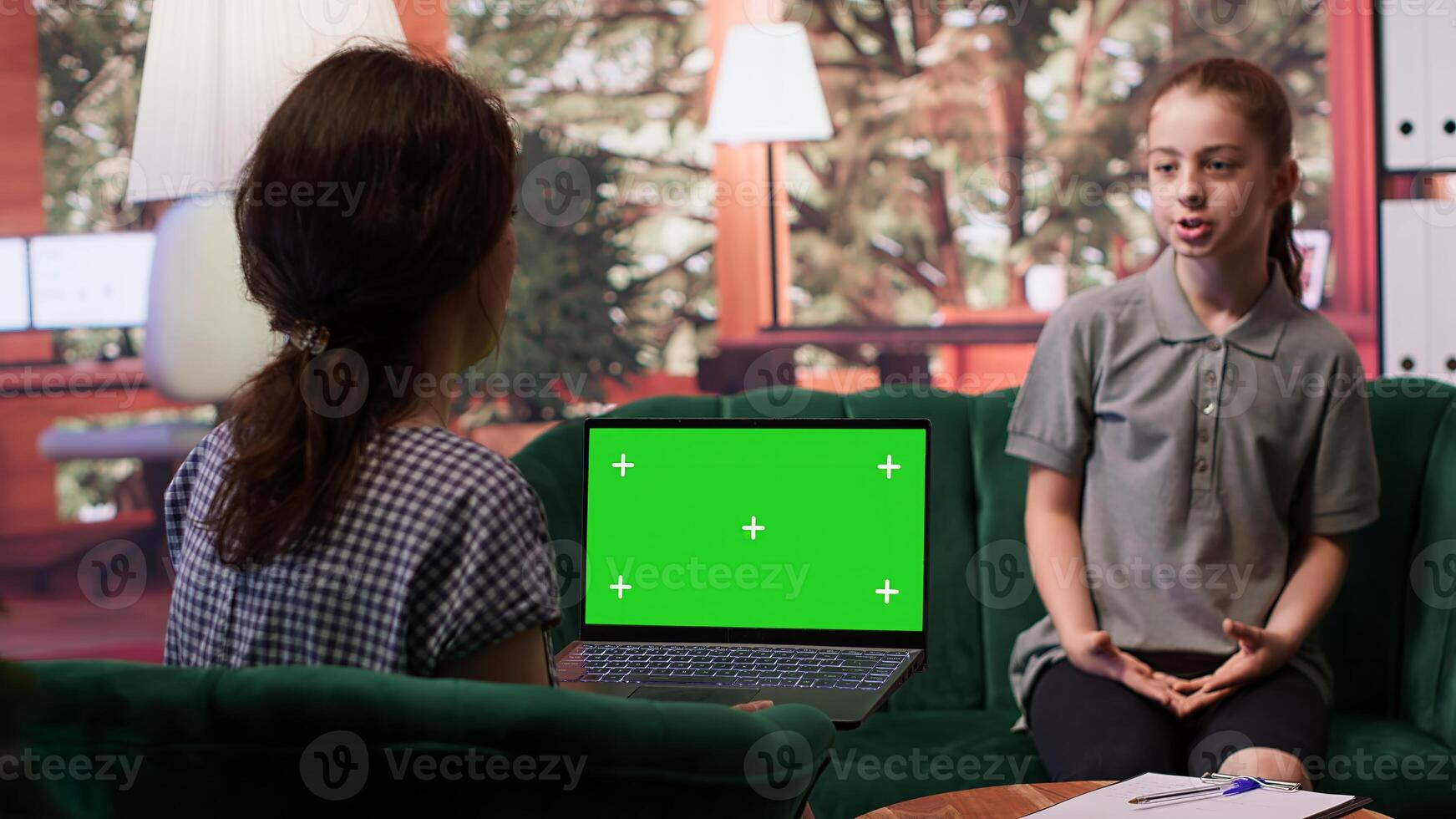 Adolescent in therapy session focused on mental health next to isolated mockup screen, works on emotional well being. Psychotherapist supporting the teen to manage anxiety and depression. Camera A. photo