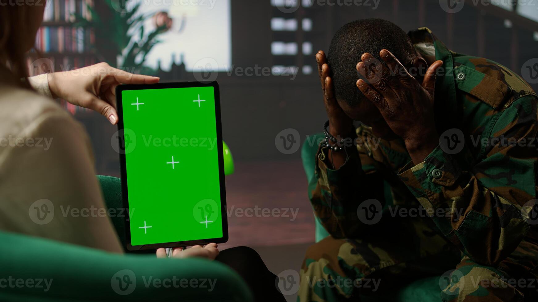 Black army soldier crying at therapy session next to chroma key screen, seeking professional support for PTSD and trauma recovery. Discussions for armed forces mental health care. Camera A. photo