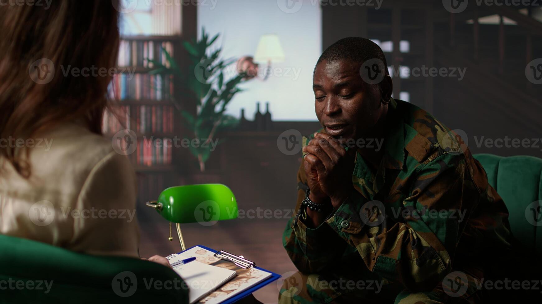 Black armed forces warrior faces trauma and anxiety at counseling session, addressing PTSD and talking about horror war scenes. Distraught trooper shares war flashbacks. Camera A. photo