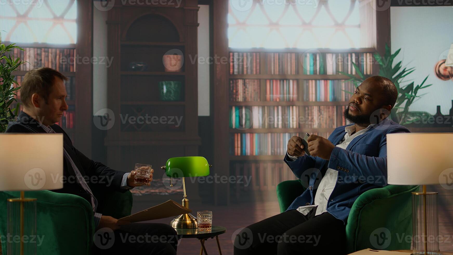 Diverse intelligence duo review a confidential hard disk over a drink, headquarters meeting for data security and team collaboration. Secret agents protecting crucial CIA information. Camera A. photo