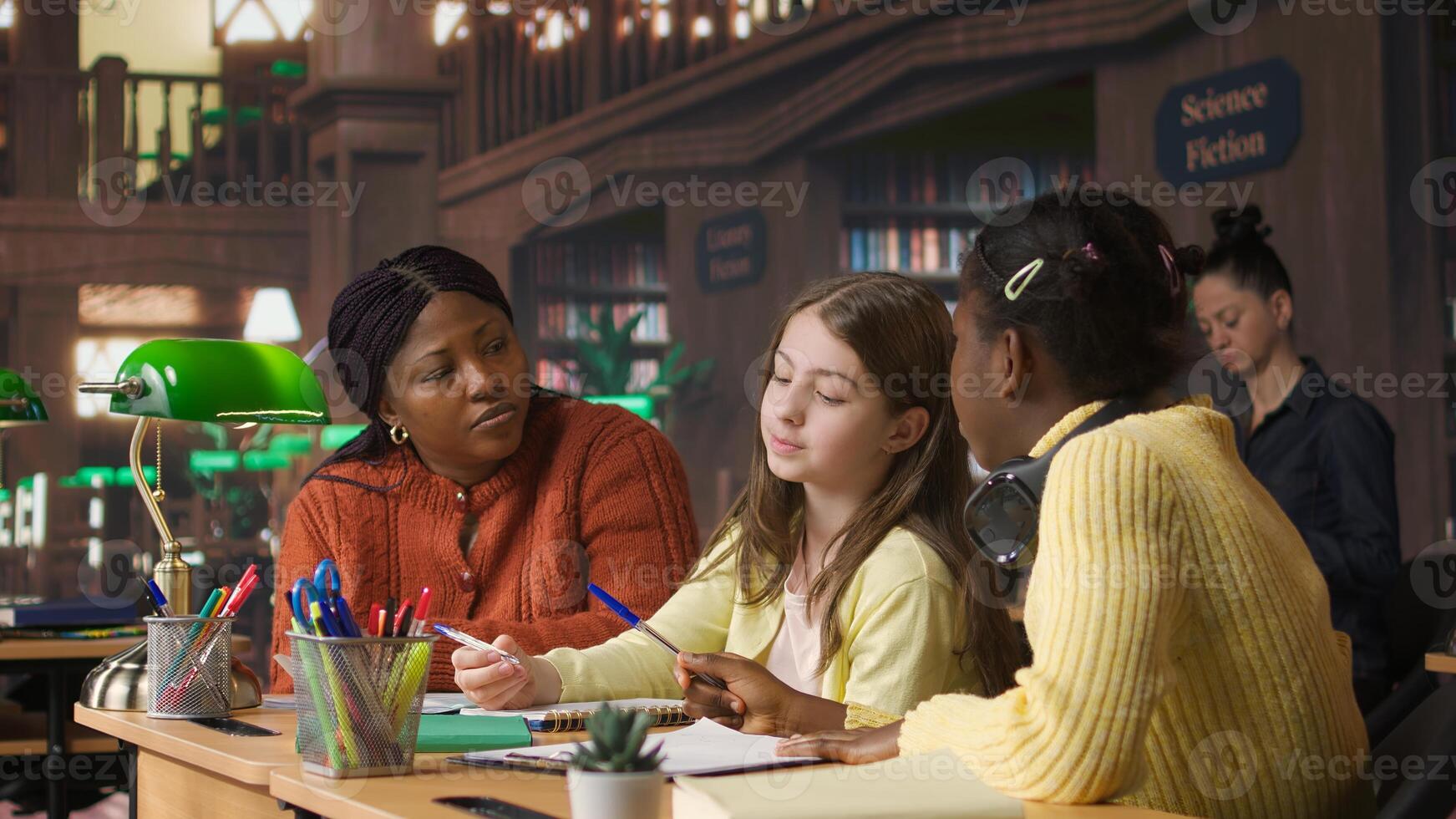 Elementary school professor engaging with girls students during private lessons, provides tutoring and guidance on specific curriculum subjects. Teacher helping classmates with ideas. Camera A. photo