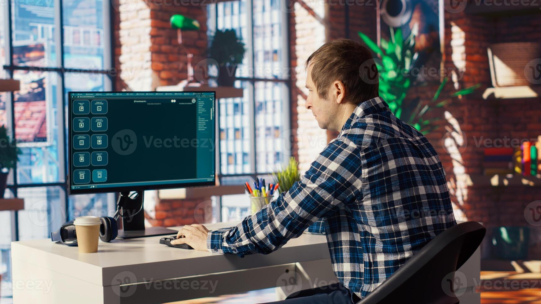 Man seated at desk using AI LLM chatbot software in modern urban home office. Person requesting help from large language model program on computer in bright apartment workspace, camera B photo