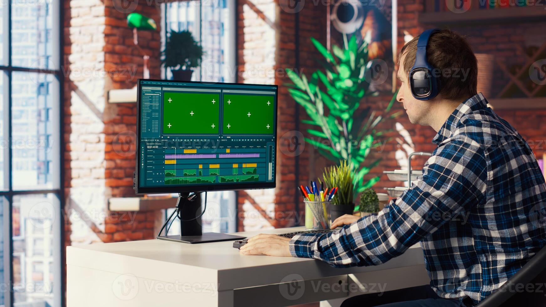 editor selecting key frames to use while doing montage, working from home on green screen computer. Man using mouse to edit movie project footage on chroma key PC in apartment, camera B photo