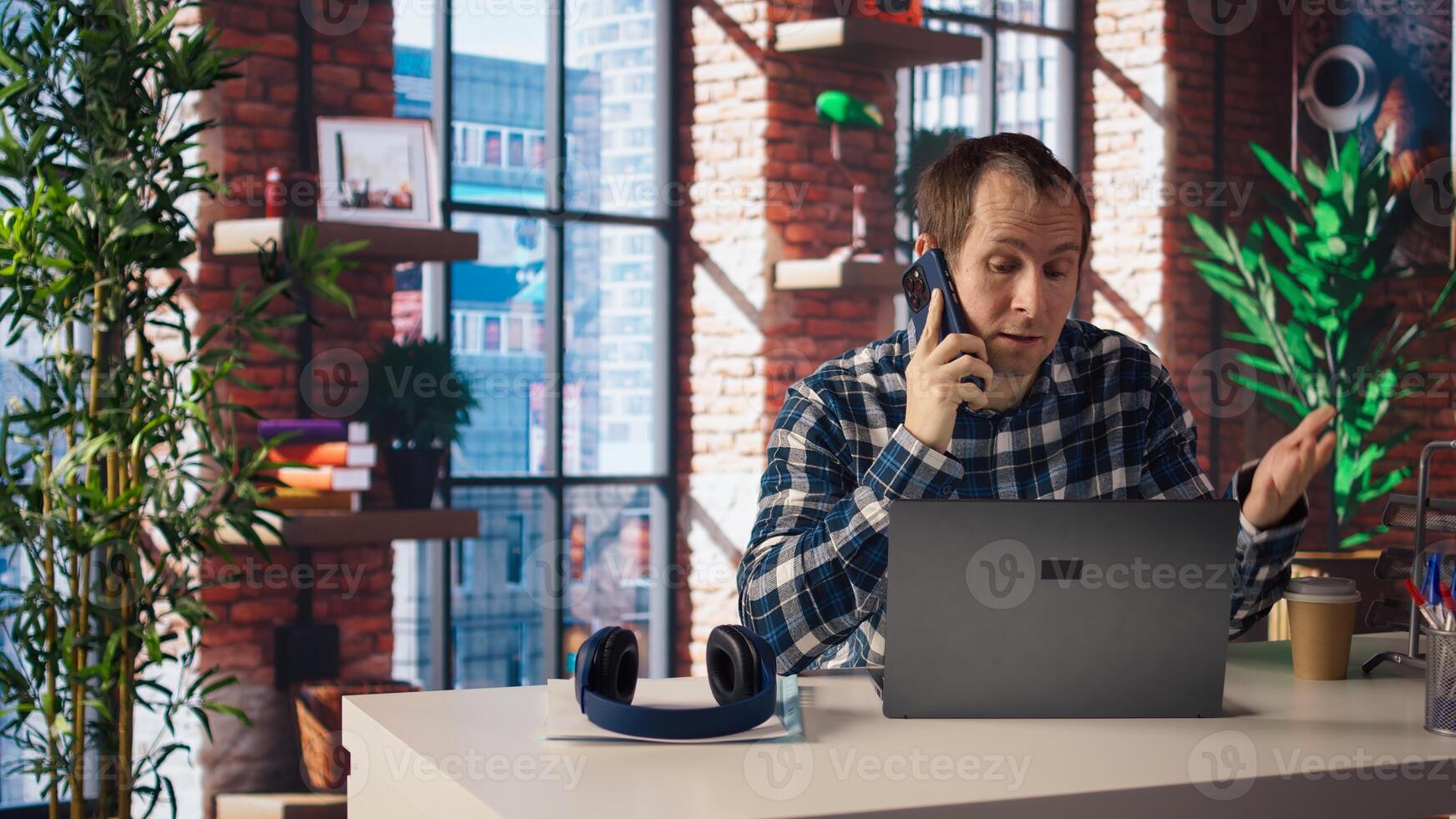 Manager in home office sitting at desk in front of laptop, calling employee to confront him about mistakes. Supervisor using notebook to do job online, doing telephone call to scold worker, camera A photo