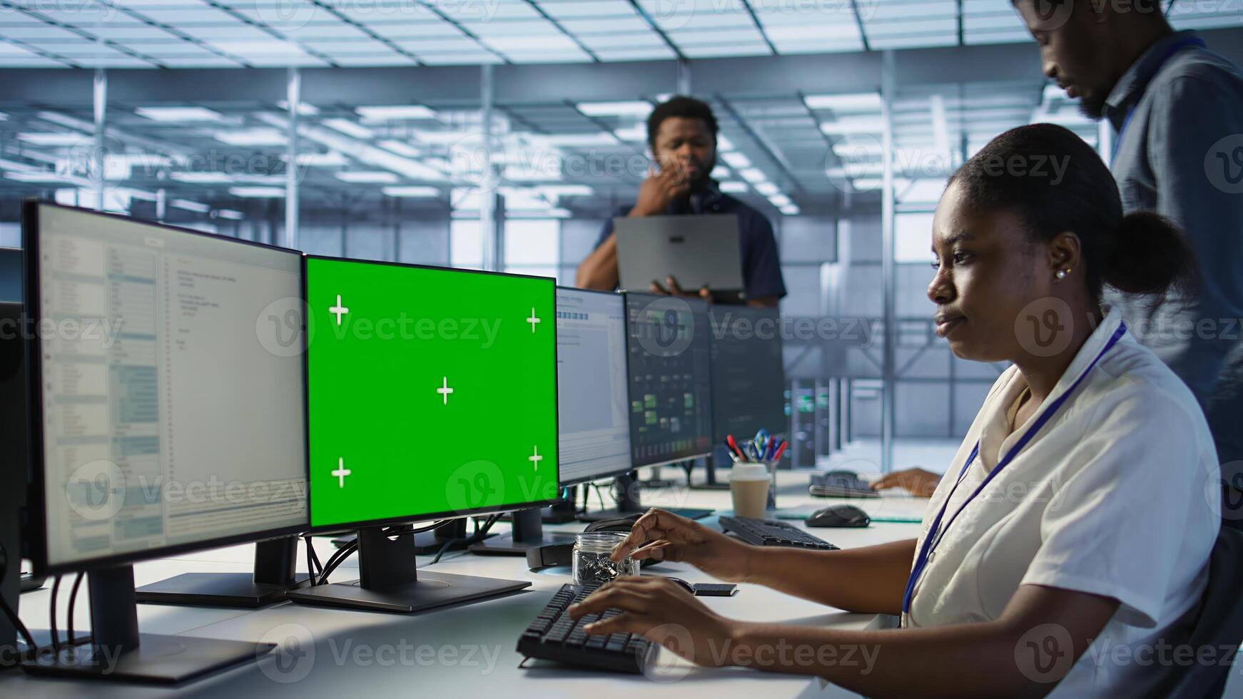 System administrator in server hub ensuring data remains shielded from potential threats using chroma key PC. Woman safeguarding data center against hackers with mockup computer, camera A photo