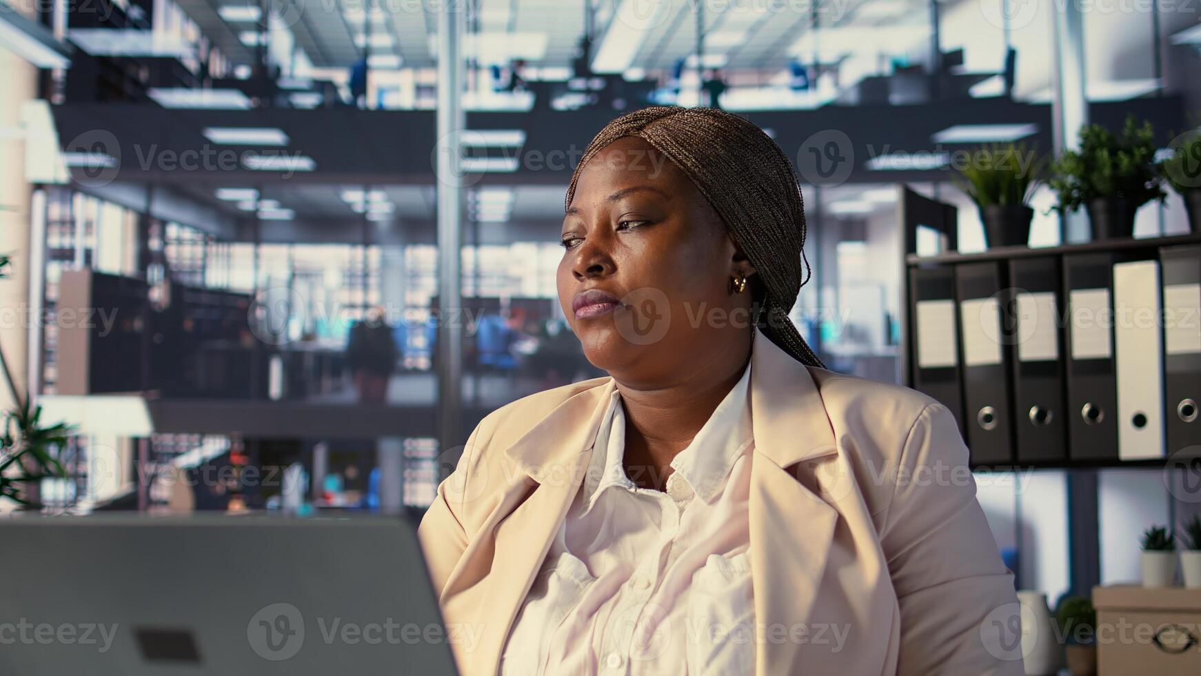 Ambitious CEO leader taking a break and relaxing in her own office, looking out the window at urban corporation center. Entrepreneur resting in her leader chair, success story. Camera B. photo