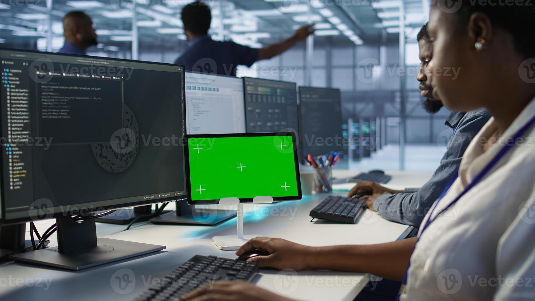 IT experts using green screen tablet, working together in server farm to optimize it for data processing requirements. Close up of coworkers coding on chroma key device in data center, camera A photo