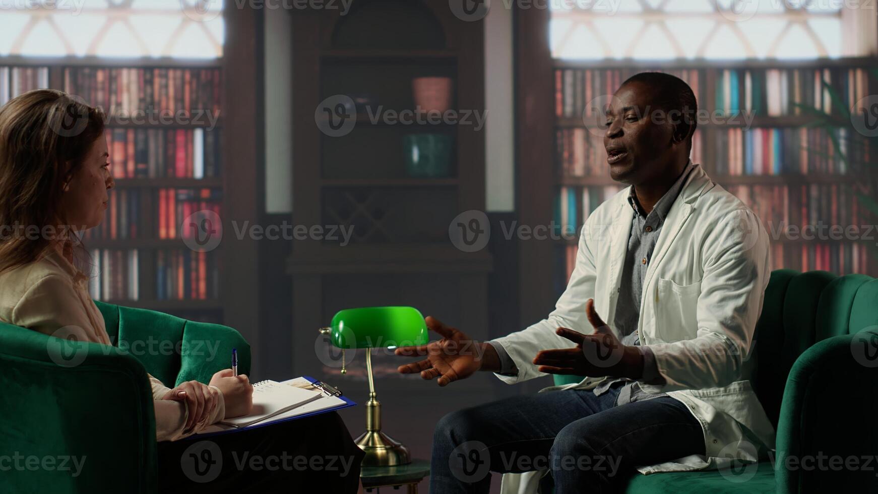 Black surgeon opening up about hard patient cases and PTSD, psychologist listens to advice in a counseling session. Doctor sharing feelings after losing people, trauma support. Camera B. photo