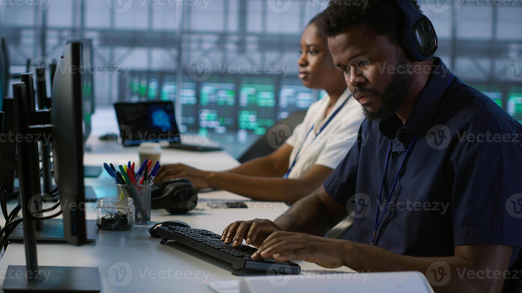 Engineer in server room looking over documents, developing disaster recovery plans ensuring minimal downtime. Worker reading paperwork in data center, using analytics to monitor performance, camera A photo