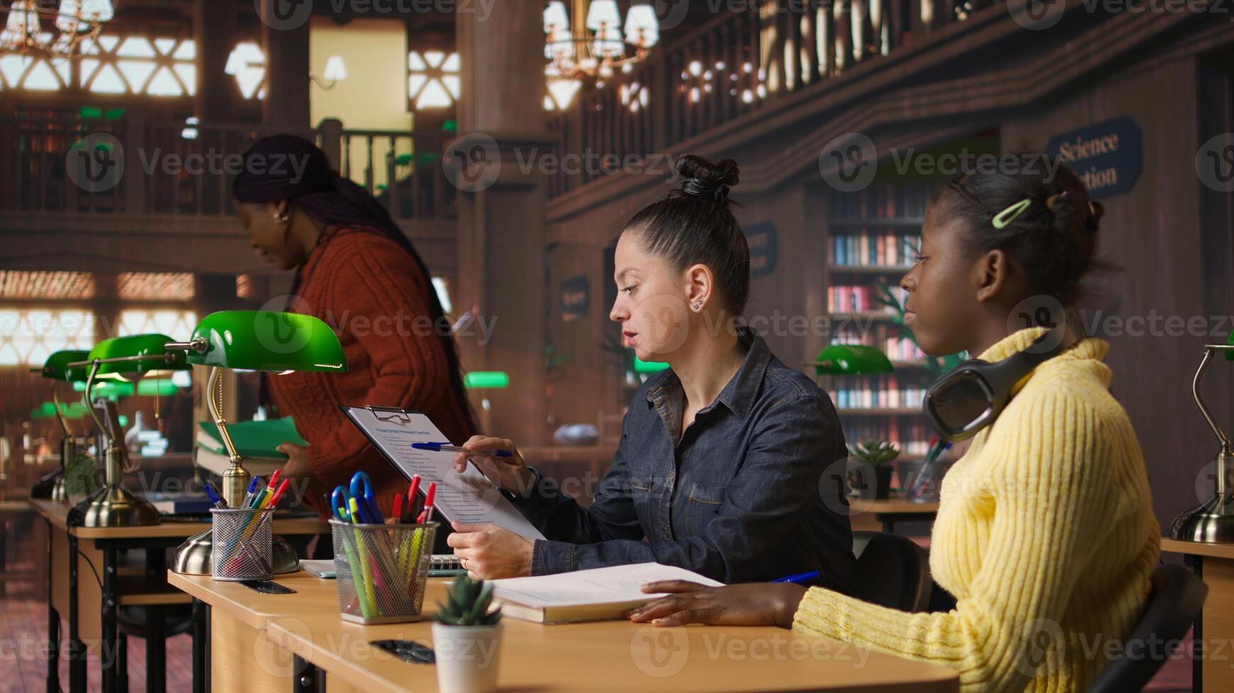 Portrait of cute young schoolgirl entering the library to study in peace, carrying textbooks and learning materials. Preteen scholar preparing for her school lessons, homework session. Camera A. photo