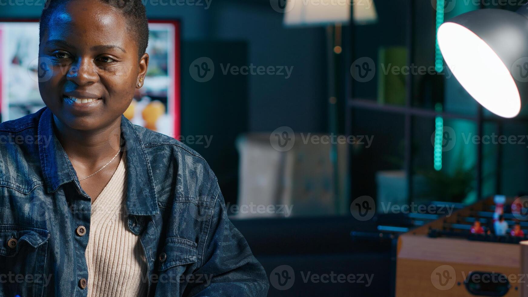 Jolly freelancer noting down ideas on paper using pen while teleworking. Upbeat remote employee working at home office desk, reading information on laptop and writing in notebook, camera A photo