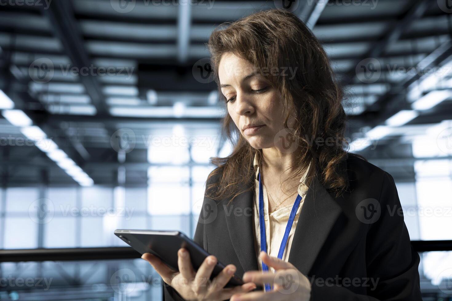 Computer scientist in data center automating routine maintenance tasks with tablet, executing diagnostic scripts. Woman using device, adjusting cooling and power settings photo