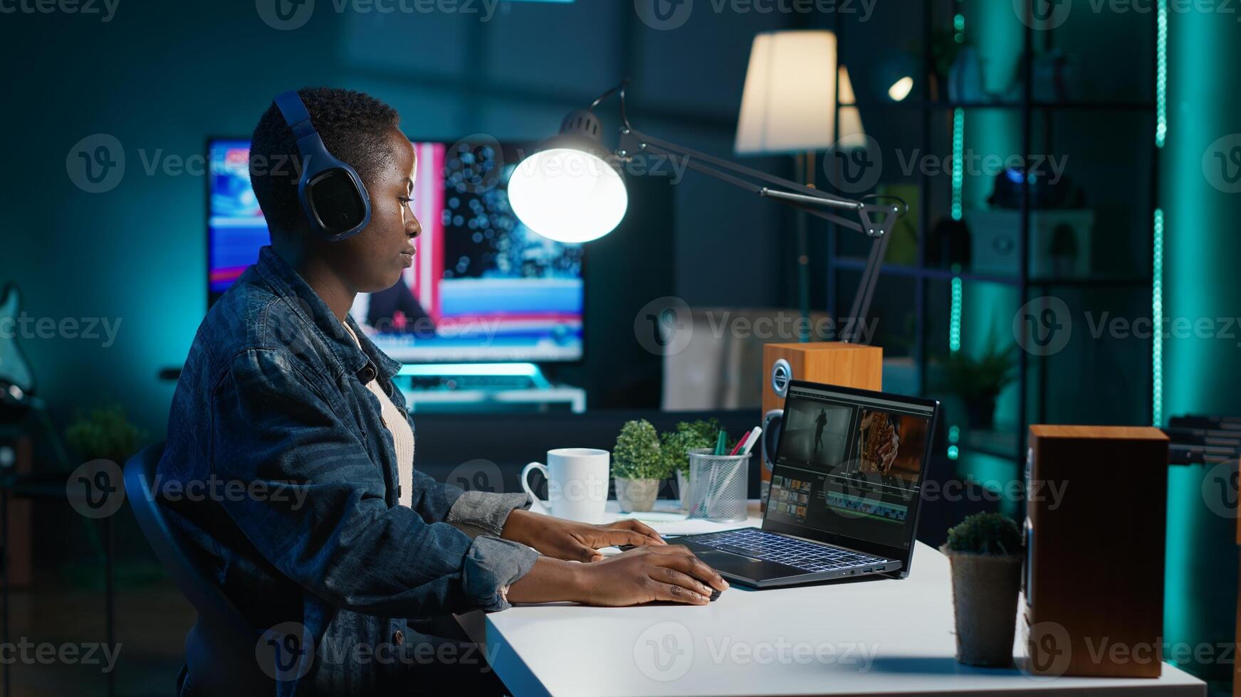 editor adds sound effects to filmed footage, working in home studio. Videographer using headphones to test and improve audio quality, editing clips with professional software, camera A photo