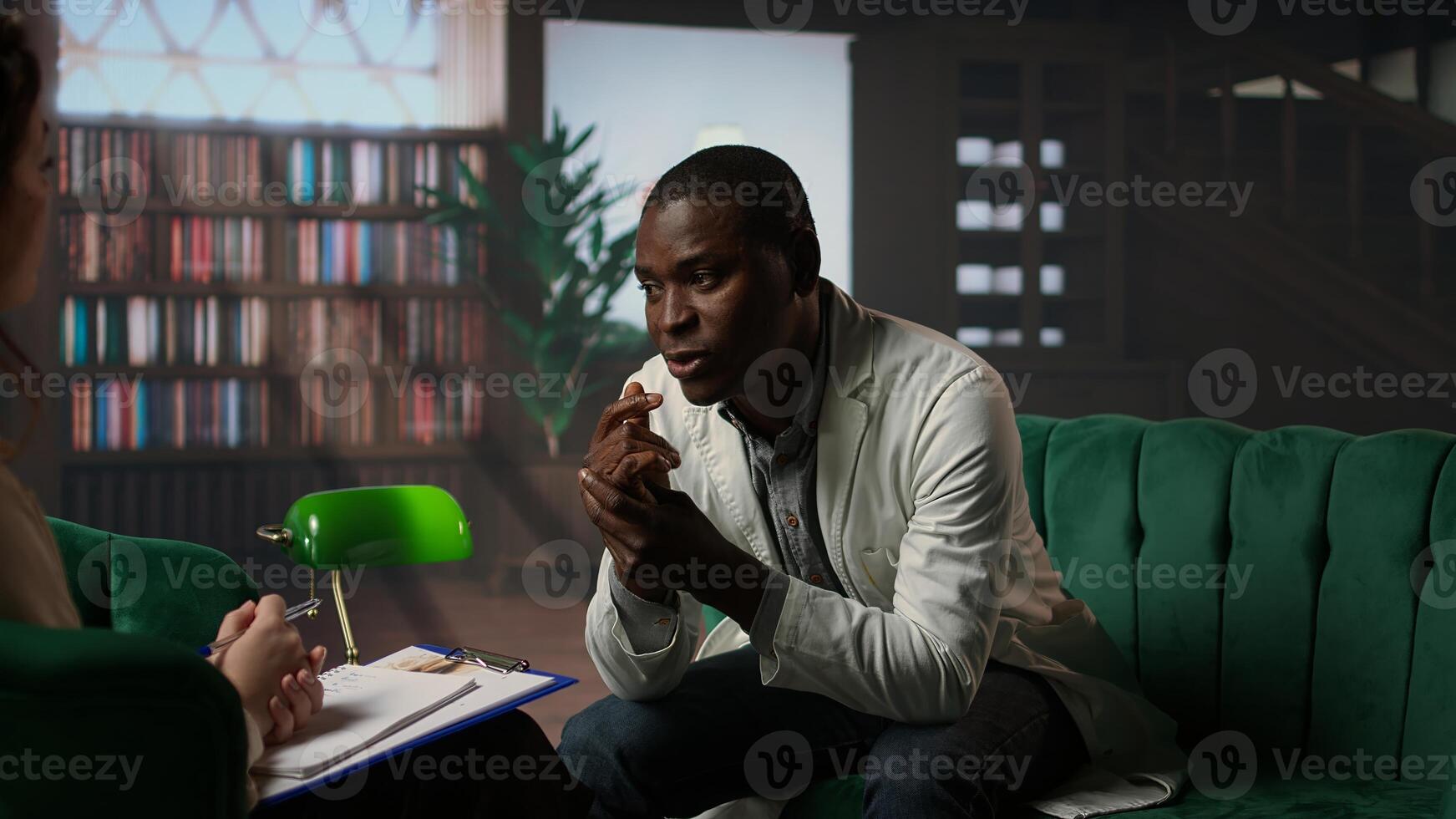 Psychologist in a serious consultation with a doctor physician in cabinet, listening to career difficulties and mental health struggles. Depressed medic discussing about PTSD in therapy. Camera A. photo