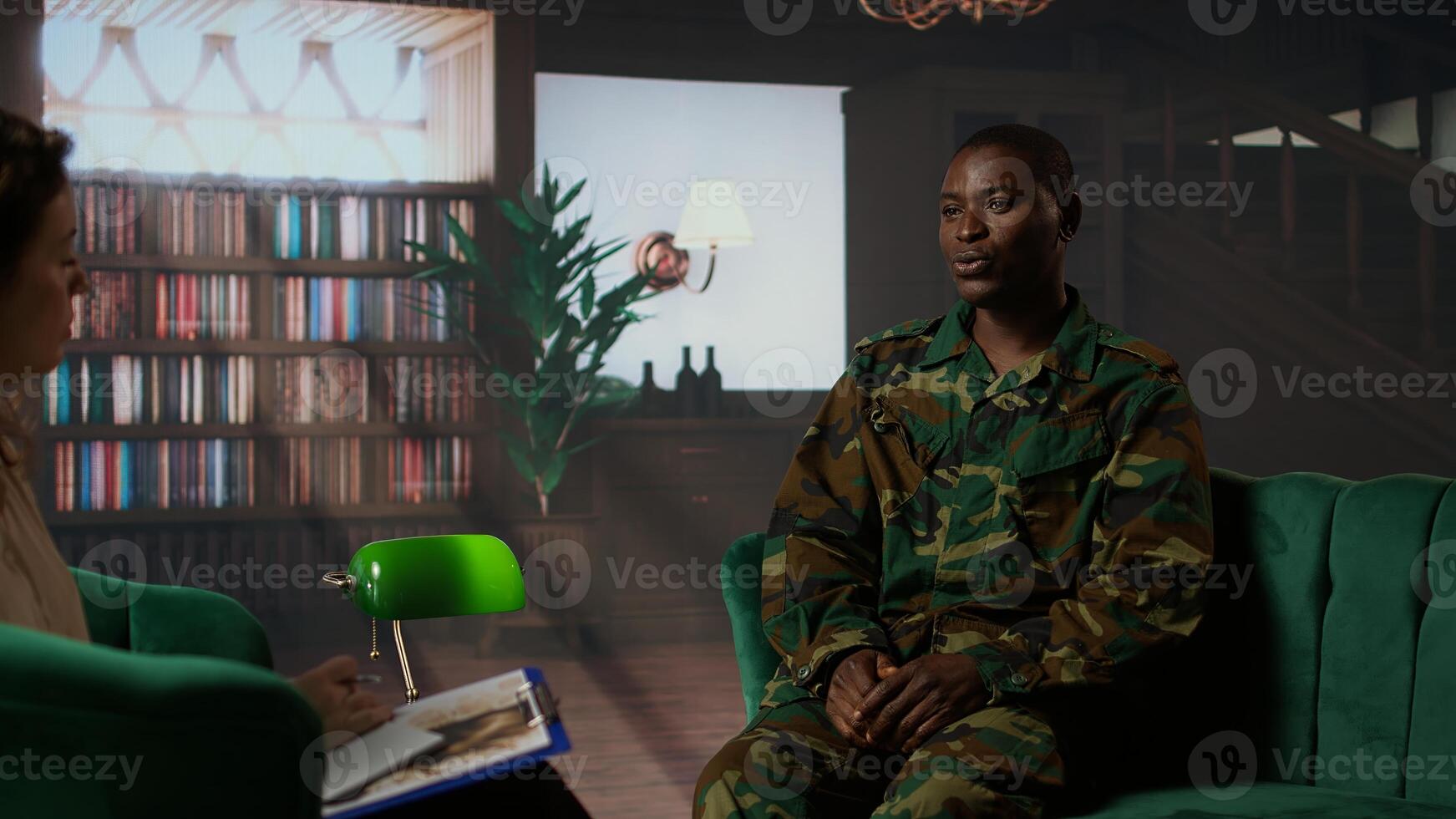 Camouflaged black army trooper meeting with a psychologist at therapy, seeking support for PTSD and trauma recovery. Discussions for armed forces mental health care and counseling. Camera A. photo