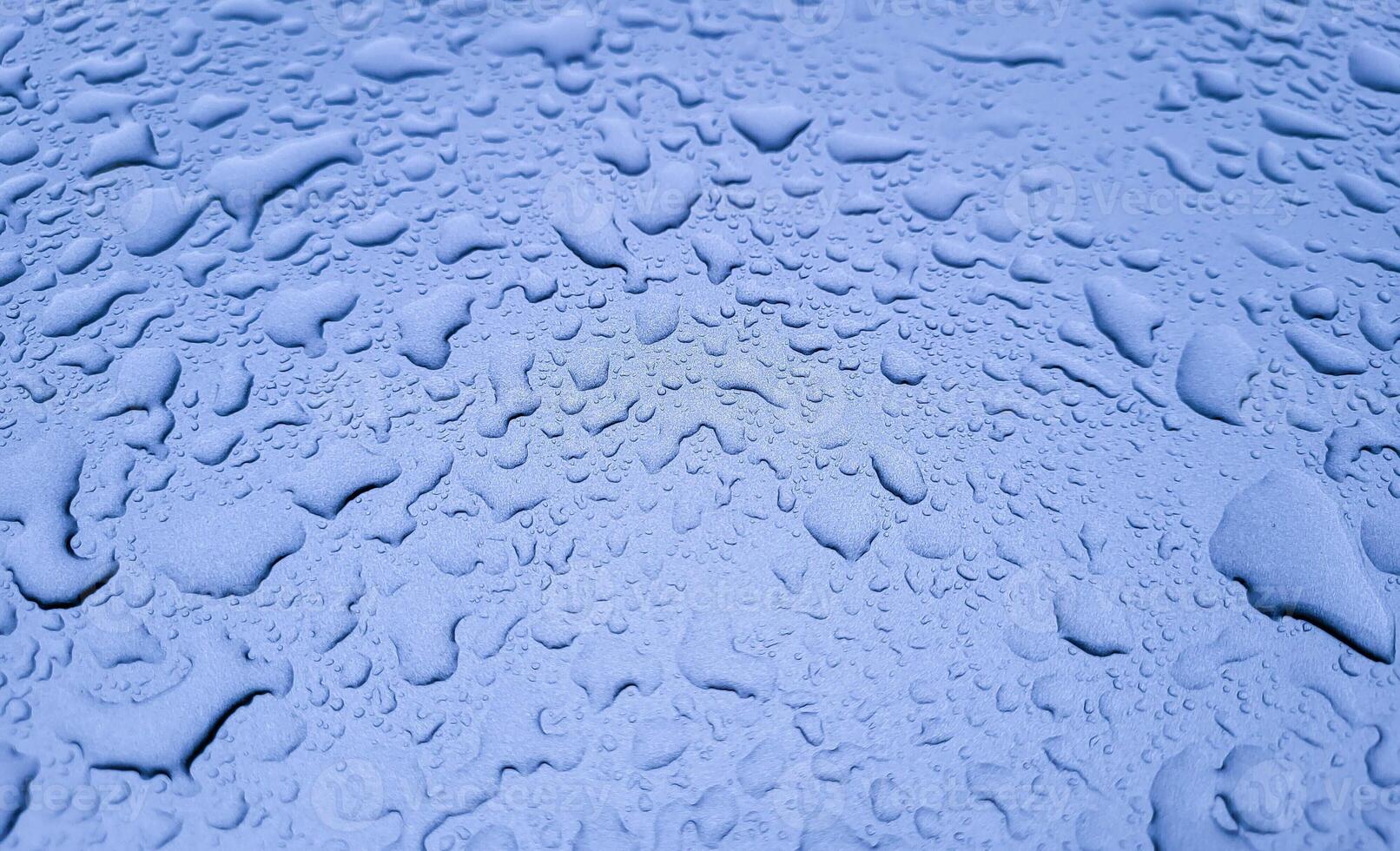 Large raindrops on the lilac hood of the car photo