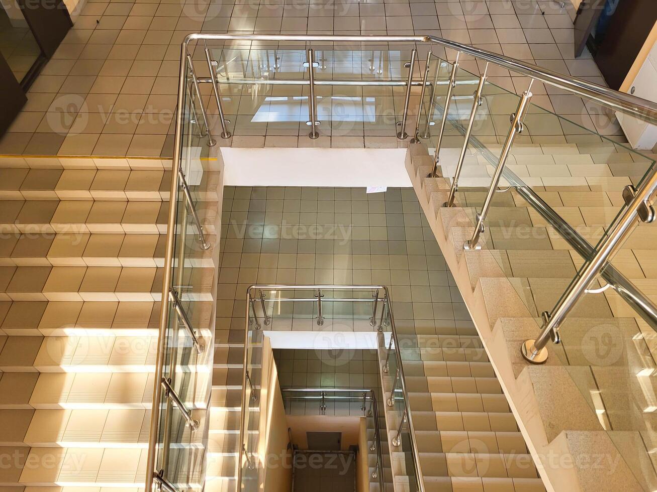 Top view of staircases with handrails and glass railings. photo