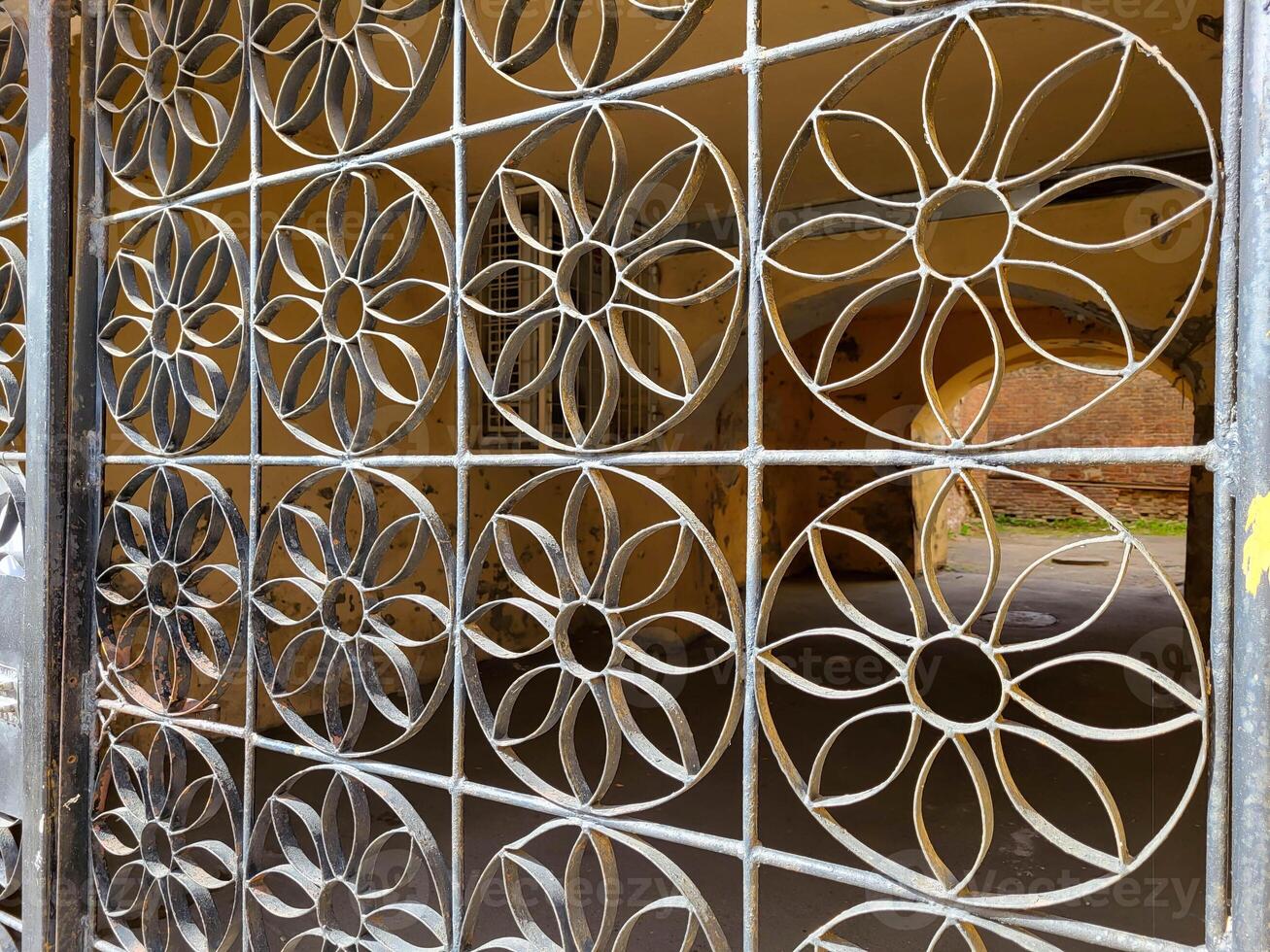 Gate with metal grating with circles and flowers. photo