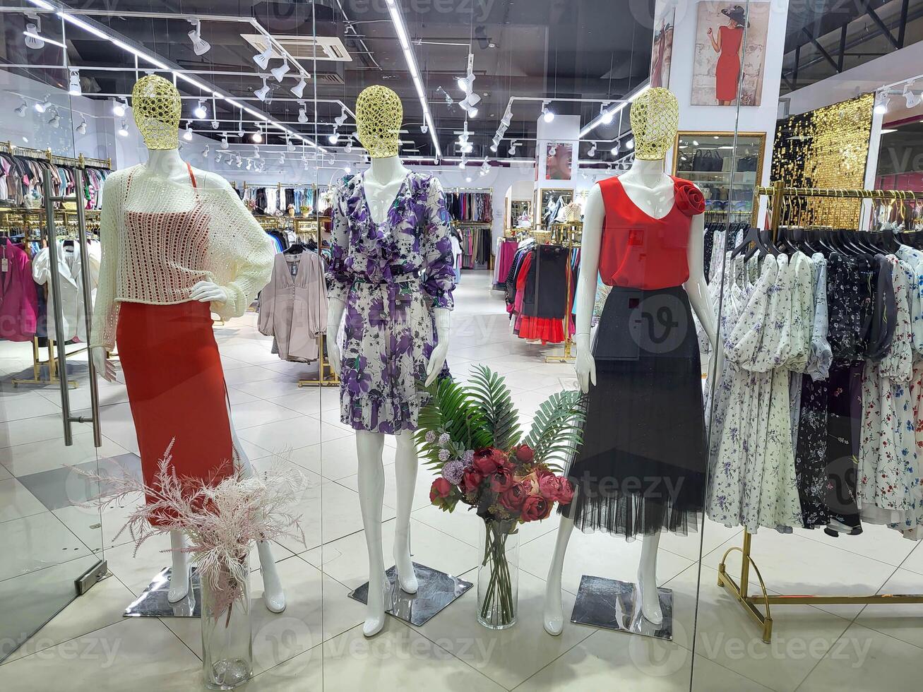 Three female mannequins in summer clothes in a shop window photo