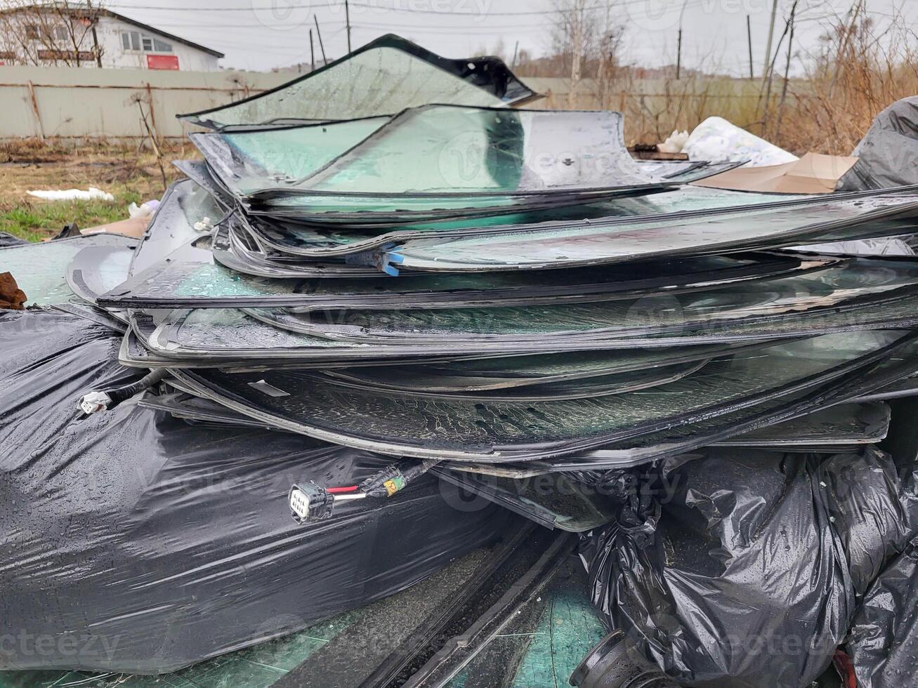 A large pile of broken auto glass in a garbage dump photo